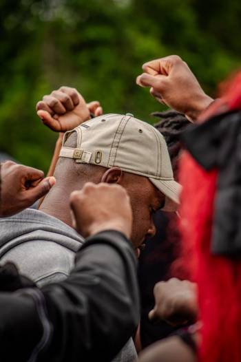 Men huddled together holding up fist in victory