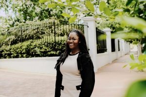 Young Black woman standing in front of wrought iron fence