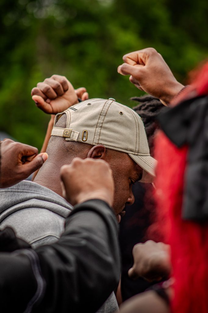 Men huddled together holding up fist in victory