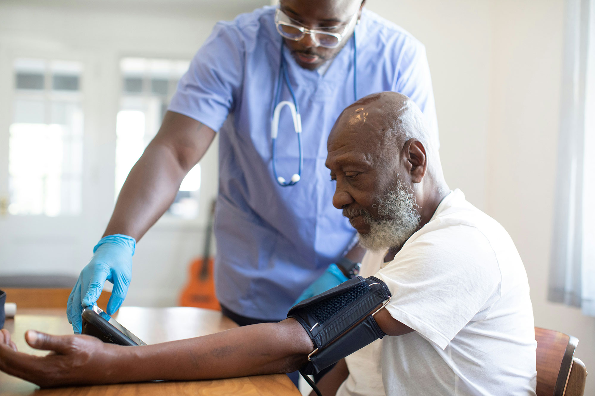 An older man gets his blood pressure checked at the doctor’s office