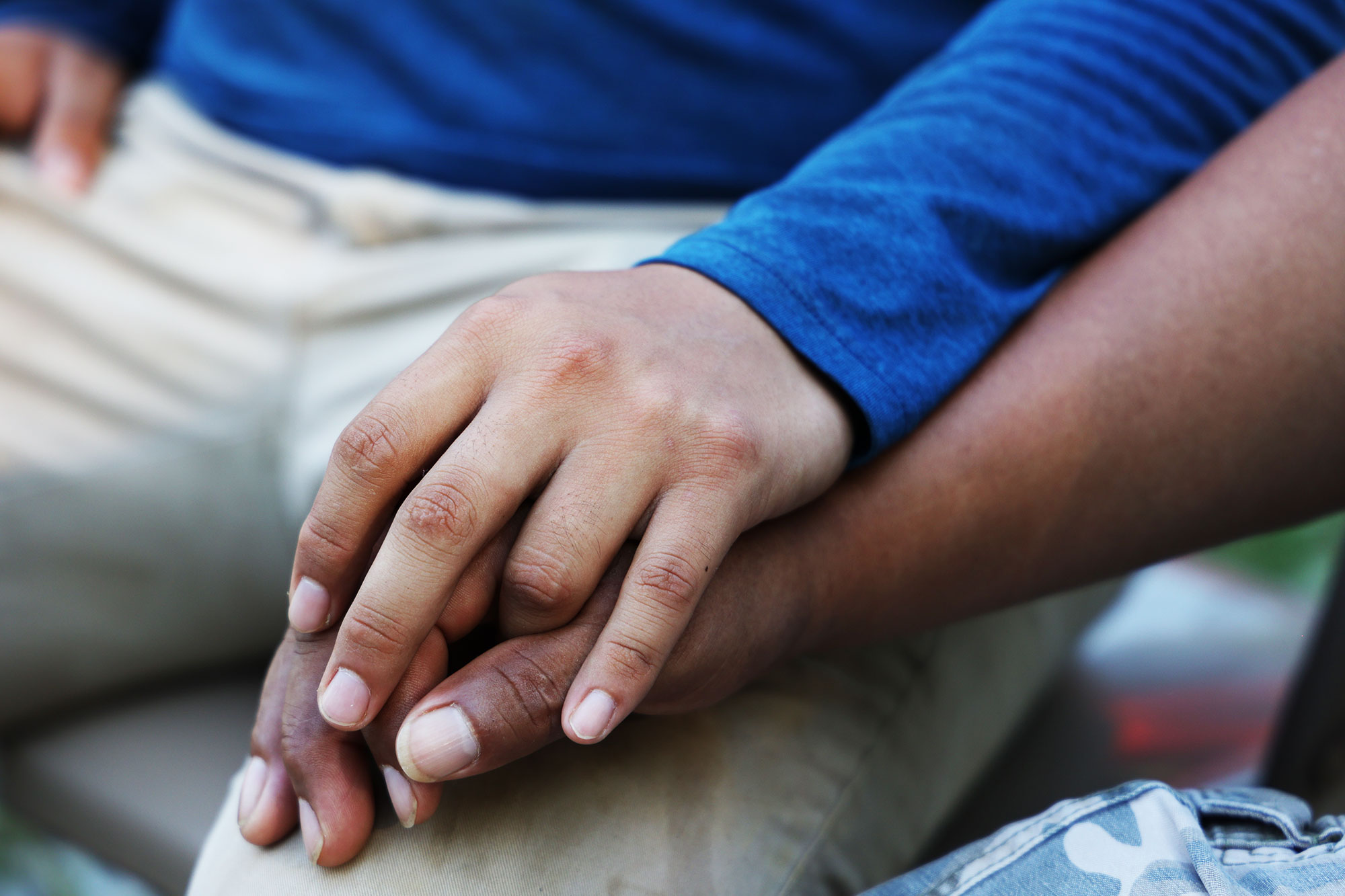A closeup of two men’s hands clasped together